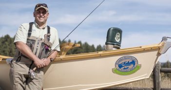 A man standing next to a fishing boat.