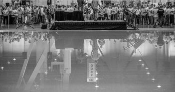 A group of people standing in front of a pool.