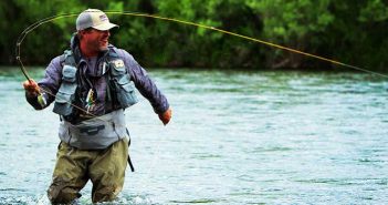 A man is fly fishing in a river.