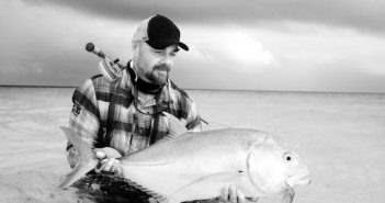 A man holding a fish in the water.