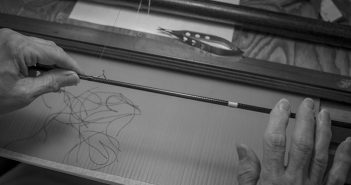 Black and white photo of a person working on a loom.