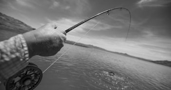 A black and white photo of a person holding a fishing rod.