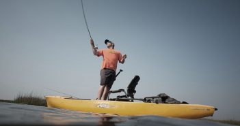 A man fishing from a kayak on the water.