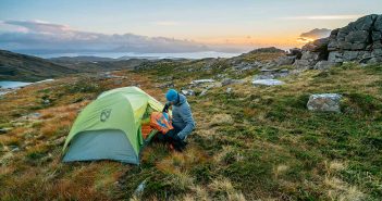 A person setting up a tent on a mountain.