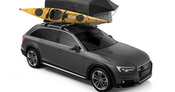 A grey suv with a kayak on top of it.