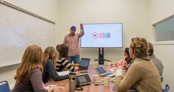 A group of people sitting around a table in a conference room.