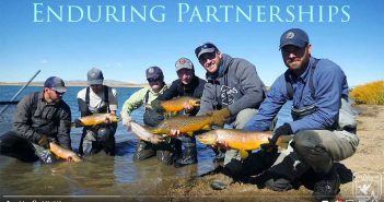 A group of men holding fish with the words enduring partnerships.