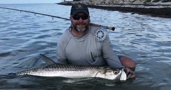 A man holding a fish in the water.