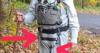 A man wearing a fly fishing vest and waders.