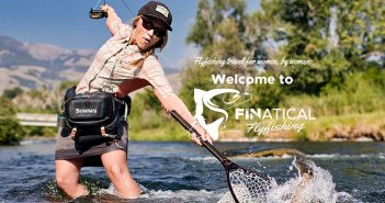 A woman is fishing in a river with a fly rod.