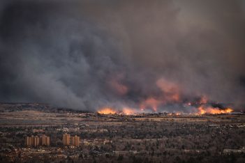 A large fire burns near a city.