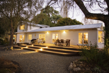 A white house with a deck at night.