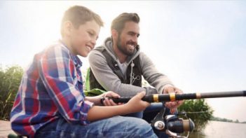 A father and son fishing on a dock.