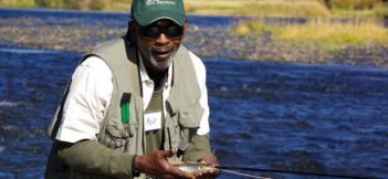 A man holding a fly fishing rod in a river.