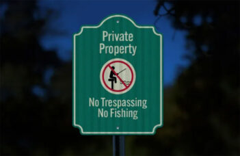 Green sign indicating "Private Property" with a symbol of a person fishing crossed out. Text below reads "No Trespassing, No Fishing.