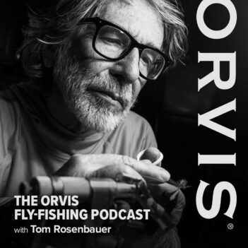 Black and white image of a man tying a fishing fly, with text reading "The Orvis Fly-Fishing Podcast with Tom Rosenbauer" and the word "Orvis" vertically aligned on the right.