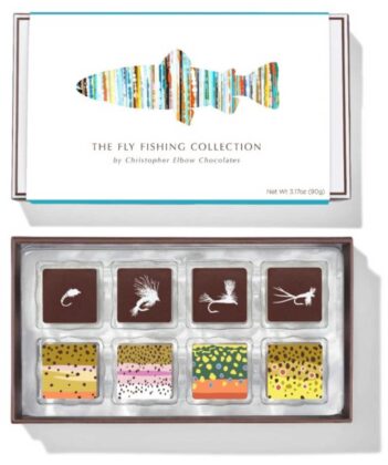 A box of chocolates labeled "The Fly Fishing Collection" by Christopher Elbow Chocolates, featuring chocolates with colorful fly fishing designs.