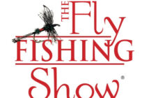 Logo for "The Fly Fishing Show" featuring red text and an illustration of a fishing fly.